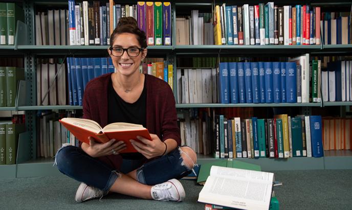 Student at the library sitting with a book